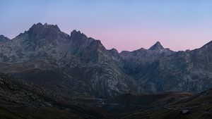 Panorama während der blauen Stunde mit schönem rosa Licht hinter den Bergen der französischen Alpen.