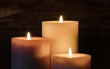 Trois flammes de bougies allumées la nuit sur Alex Winter