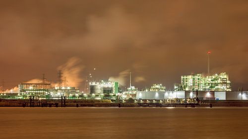 River and embankment, moored ship near petrochemical industry