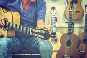 Mann stimmt Gitarre