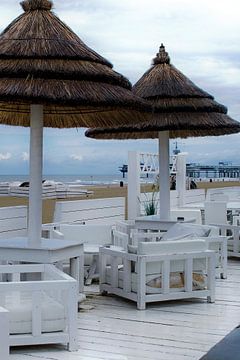 Foto van een wit strandpaviljoen. van Therese Brals