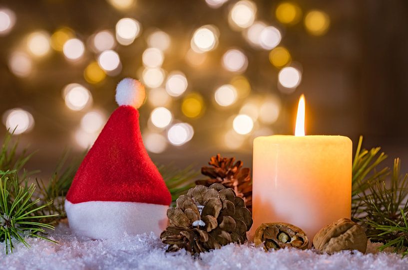 Rote Weihnachtsmannmütze mit Kerze und unscharfen Lichtern Hintergrund von Alex Winter
