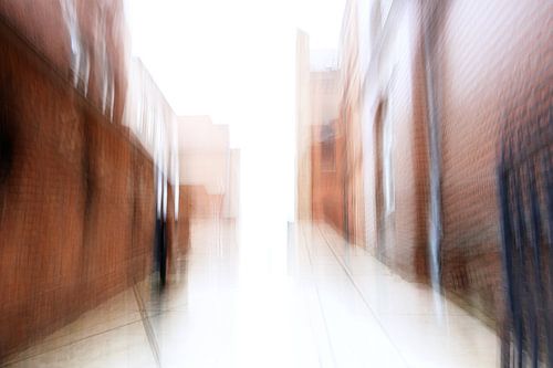 Passage flou abstrait dans la lumière entre les maisons en briques rouges de la vieille ville de Lue