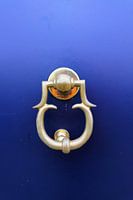 Voordeur in blauw met deurklopper.