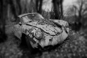 Oude verlaten roestige Porsche coupe in het bos in monochroom van Atelier Liesjes