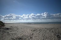 eine Wolkenreihe über dem Strand und dem Meer