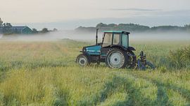 Tracteur dans un champ d'herbe sur Dirk van Egmond