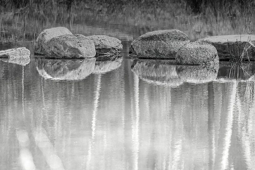 Runde Felsen und Steine in ruhigem Wasser von Frank Heinz