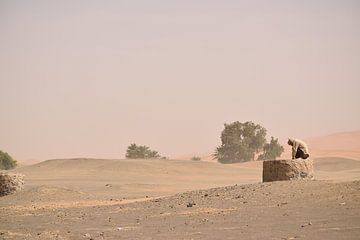 Man op waterput in woestijn, Erg Chebbi, Marokko van Lars Bruin