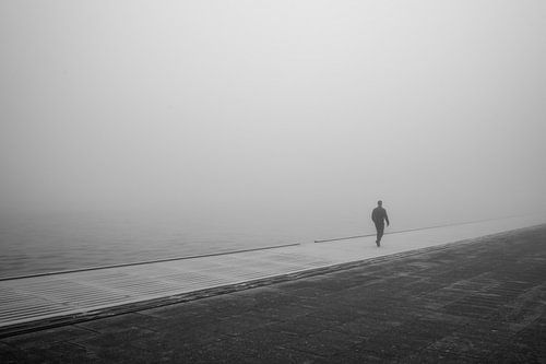 Mann zu Fuß neben dem Amsterdamer Hauptbahnhof