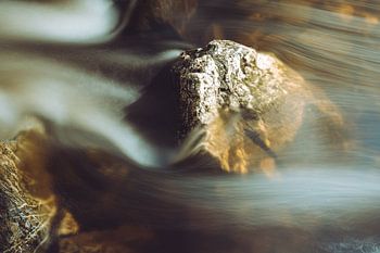 Stein im fließenden Wasser