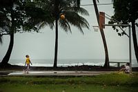 Jongens spelen basketbal naast de Caribische Zee (Costa Rica)