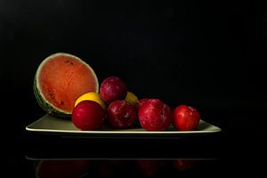 Stilleben mit einer halben Wassermelone aus Pflaumen und Zitronen