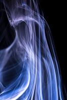 White and blue smoke against a black background