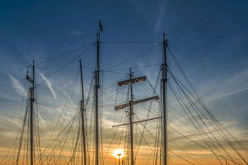 Harlingen haven en de zonsondergang door masten. van Harrie Muis