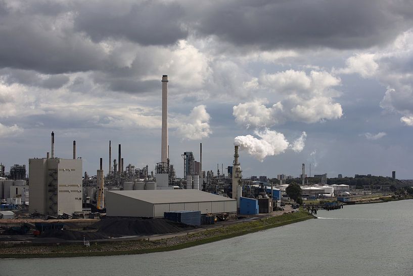 view of an industrial estate with chimney smoke by W J Kok