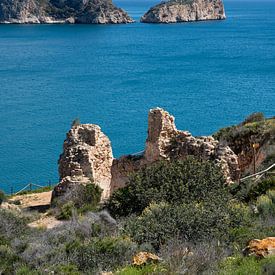 Blue sea and ruins on the rocky coast by Adriana Mueller