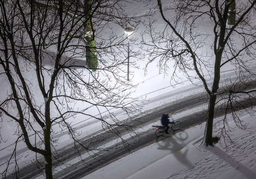 Cyclist in the snow from above by Marcel Kerdijk