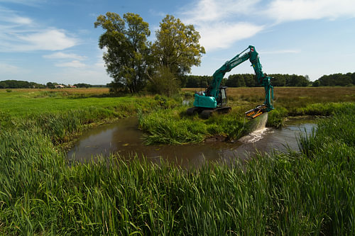 Excavator clearing a ditch