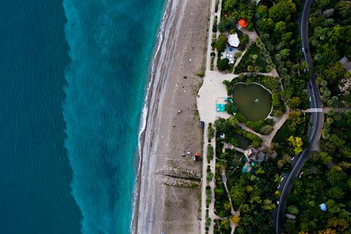 Park with a pond and the road. green park on the seafront with turquoise water and the beach. top do