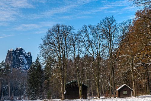 Besneeuwde top naast houten hutten