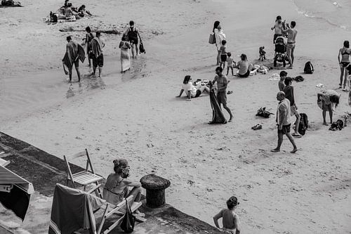 Frau schaut sich die Leute am Strand an
