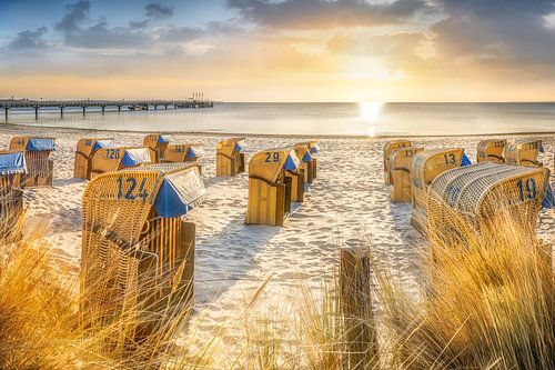 Strandstoelen op het strand van de Oostzee bij zonsopgang.