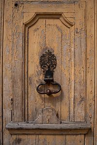 Old wooden door with decorative door knocker in Burgundy (France)