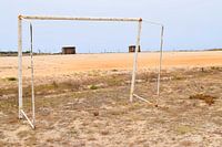 Voetbalveld met verweerd doel aan de Atlantische kust