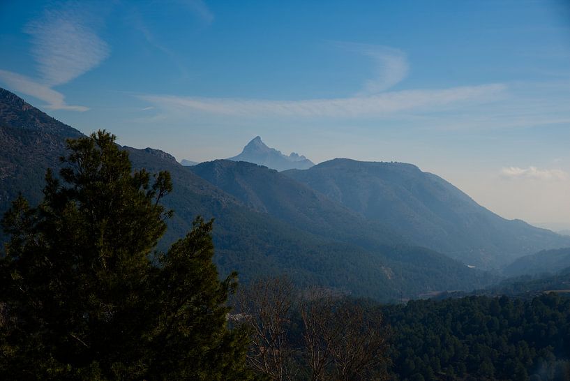 Einer nebligen Landschaft mit grünen Bergen und blauem Himmel in Spanien. von Edith van Aken