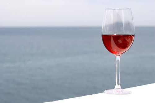 Glas met rose wijn, zee op achtergrond