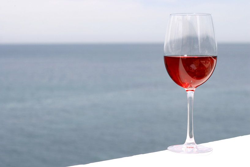 Glas mit rosa Wein, Meer im Hintergrund von Melissa Peltenburg
