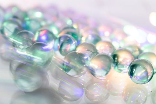 Glinsterende glazen bollen in beweging - macro op een spiegelachtergrond