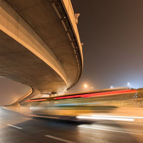 Elevated bending highway with bus in motion blur at nighttime
