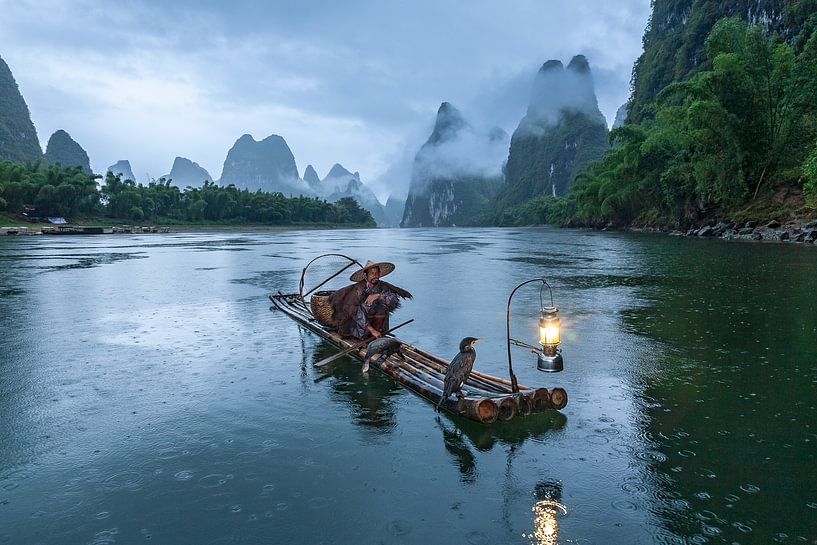 Cormorant fisherman Li River China in the rain by Joop Luimes