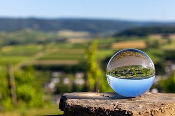 Boule de cristal avec paysage mosellan posée sur une pierre sur Reiner Conrad