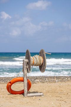 Lifebuoy with throwing device on the beach of Crete, Greece by Andreas Freund