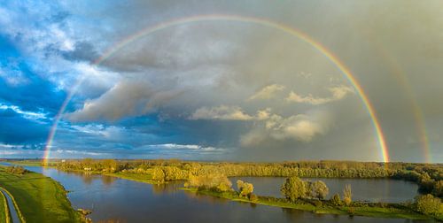 Regenboog over de IJssel tijdens een regenachtige herfstdag