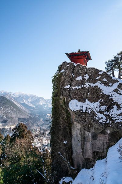 Un temple rouge au sommet d'une montagne enneigée par Mickéle Godderis