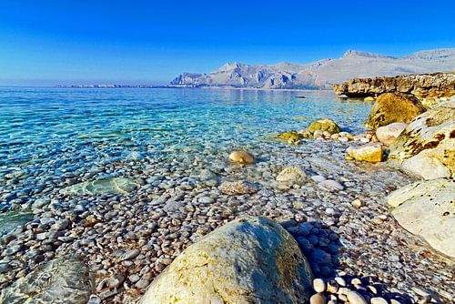 Turquoise blauwe zee met kiezels in Sicilië