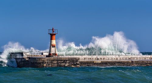 Vuurtoren op pier met hoge golven