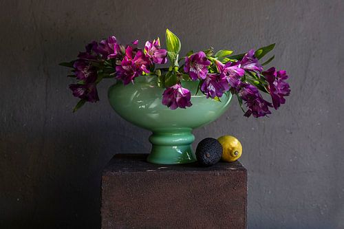 Stilleben von violetten Blumen in grüner Vase