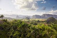 valley in Vinales, Cuba surrounded by mountains with a cloudy sky in the background