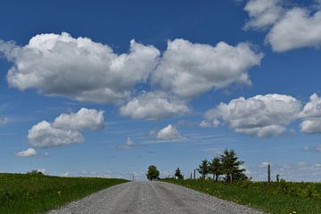 Une route de campagne sous un ciel bleu sur Claude Laprise