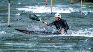 Männlicher Sportler beim Wildwasser-Kajak-Slalom auf
