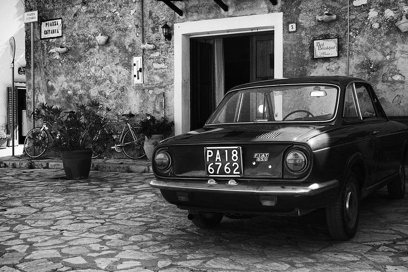 Alter FIAT 850-Oldtimer auf einem Platz in Italien in schwarz-weiß von iPics Photography