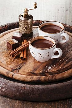 12275491 Warme chocolademelk bestrooid met witte chocolade en specerijen op donkere houten achtergro