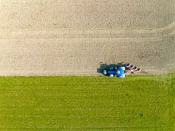 Tractor maakt de grond klaar voor het planten van gewassen van bovenaf gezien