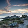 Zonsondergang bij Castro de Baroña aan zee in Portugal van Joost Adriaanse