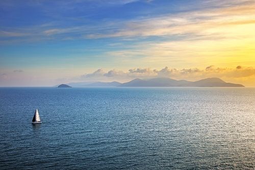 Zonsondergang op het eiland Elba vanaf Piombino en een zeilboot